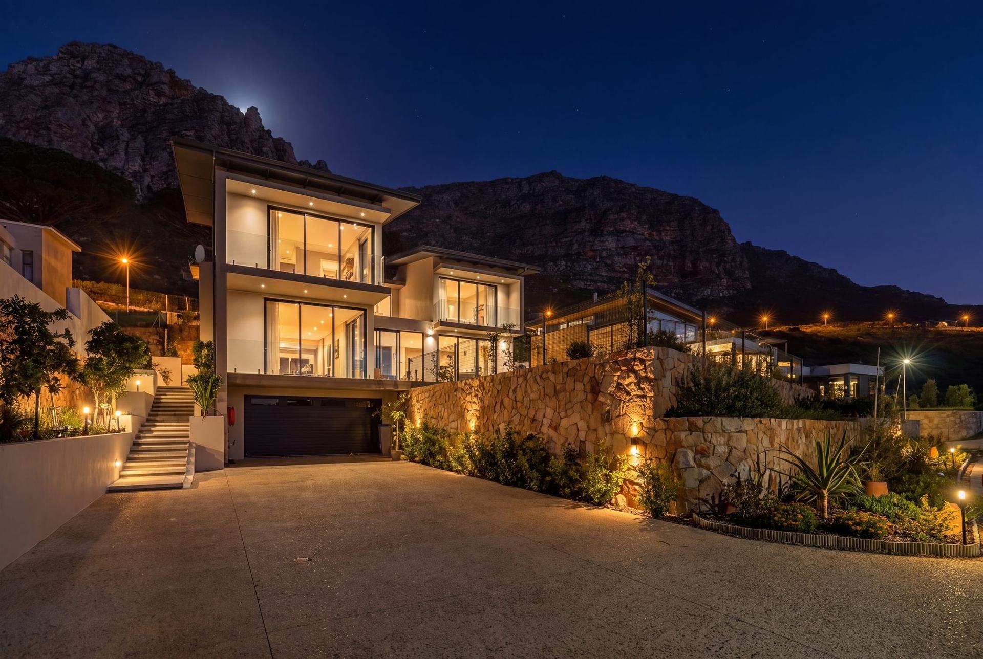 Five-bedroom home lit up at dusk below the mountain at Stonehurst Mountain Estate